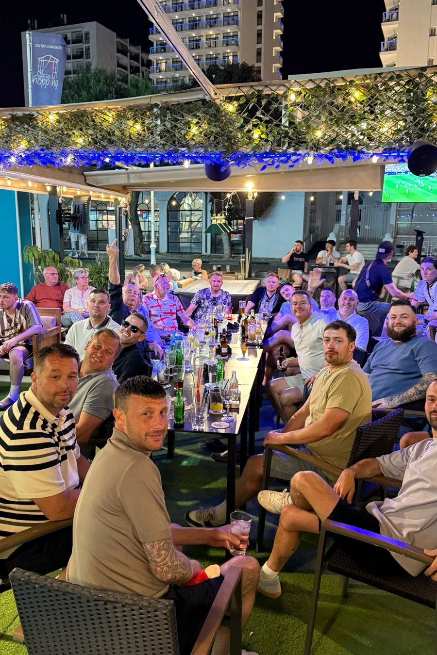 Match night on the terrace: big screens glowing over a full crowd at MT Pockets, Puerto Marina